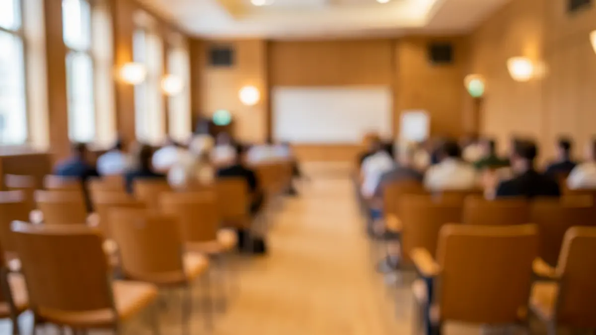 Image générique d'une salle de conférence avec des sièges vides et un pupitre, éclairage d'ambiance doux.